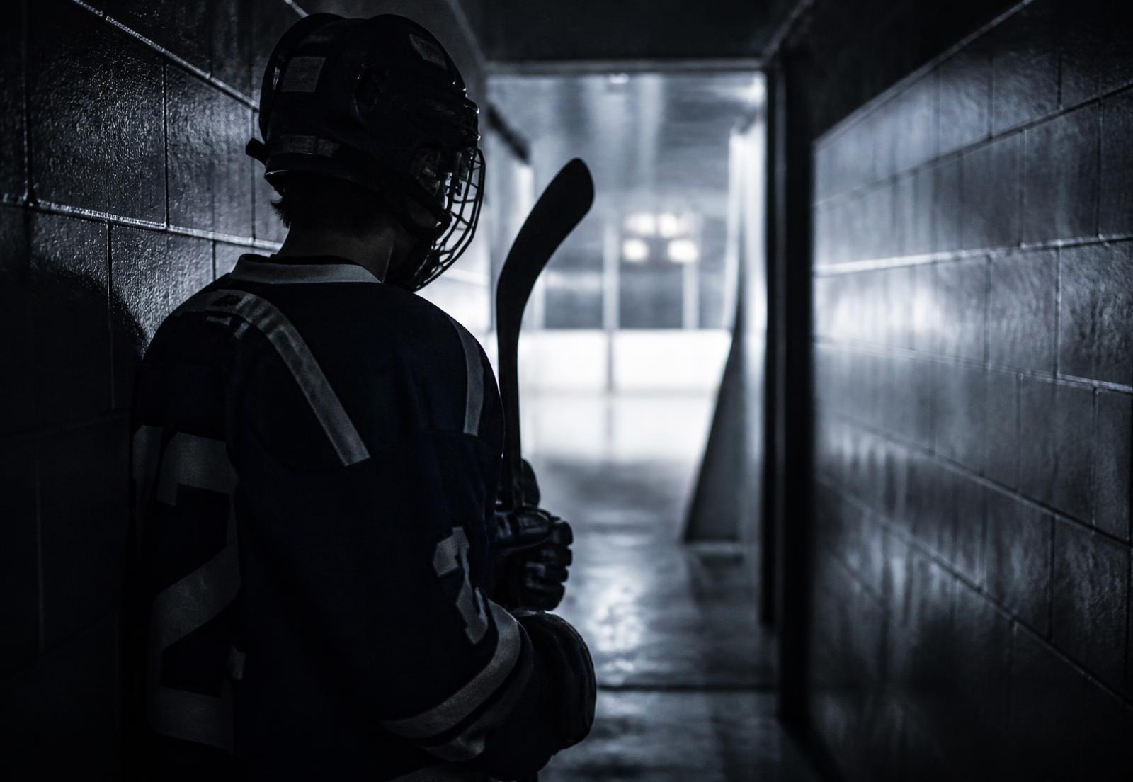 A hockey player alone in the tunnel, moments before stepping onto the ice